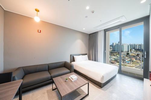 a hotel room with a bed and a couch at Sokcho Mari Vista Hotel in Sokcho