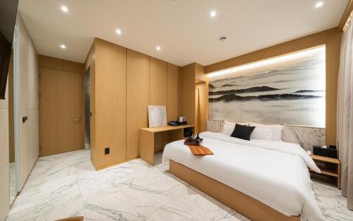 a bedroom with a large bed and a painting on the wall at Incheon BrownDot Hotel Guwol in Incheon