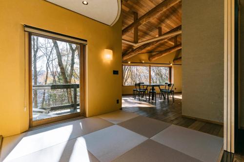 a dining room with yellow walls and a table with chairs at COCO VILLA 長瀞-Sauna- in Nagatoro