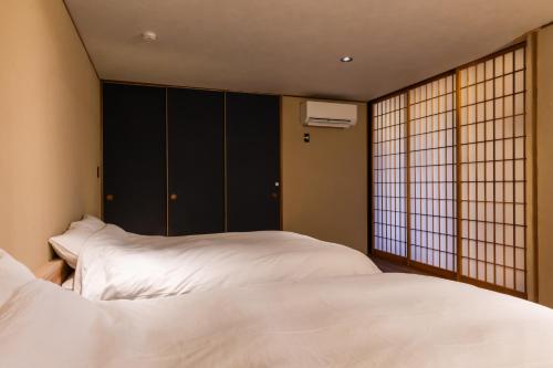 a bedroom with two beds and a window at COCO VILLA 長瀞-Sauna- in Nagatoro