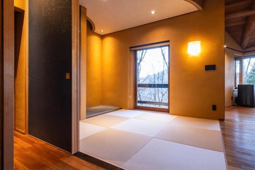 an empty room with yellow walls and a window at COCO VILLA 長瀞-Sauna- in Nagatoro