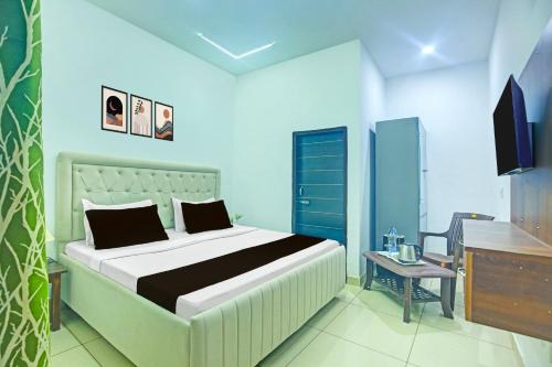 a bedroom with a bed and a desk and a television at Super Hotel O Sector 52 Chandigarh Formerly Hotel Muskan in Chandīgarh