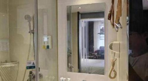 a bathroom with a mirror and a sink at City Comfort Inn Wuhan Jiefang Avenue Xinrong Light Rail Station in Wuhan