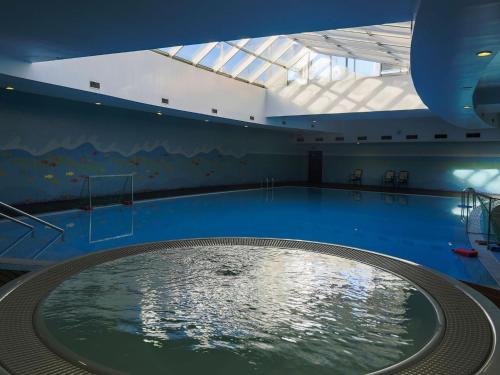 a large swimming pool in a building with a large pool at MS Aparthotel in Linda-a-Velha