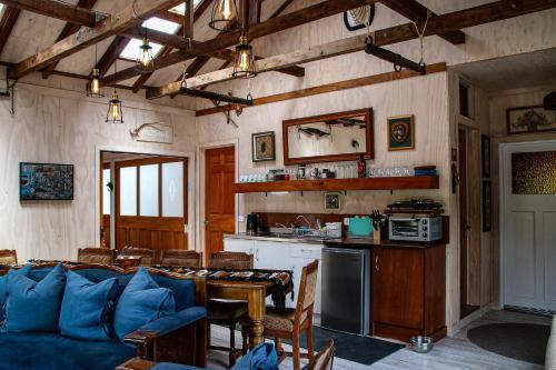 a living room with a blue couch and a kitchen at Riverstone Acres in Waihi