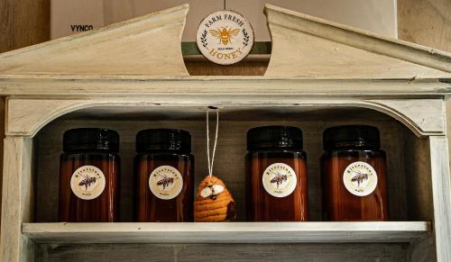 a wooden shelf with four bottles of honey at Riverstone Acres in Waihi