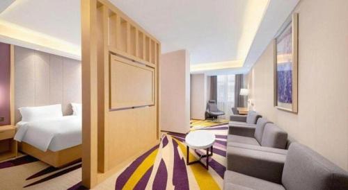 a hotel room with a bed and a couch at Lavande Hotel Changchun Gaoxin Jilin University in Changchun