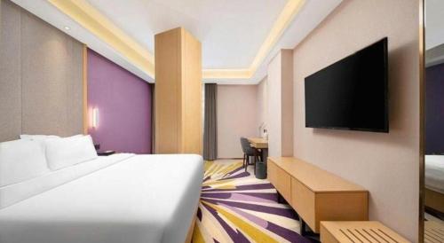 a hotel room with a bed and a flat screen tv at Lavande Hotel Changchun Gaoxin Jilin University in Changchun