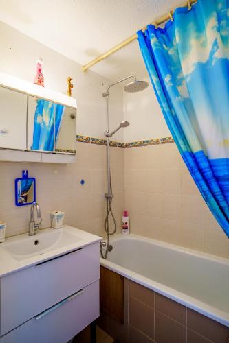 une salle de bain avec un lavabo et une baignoire dans l'établissement La Marina, à Saint Cyprien Plage