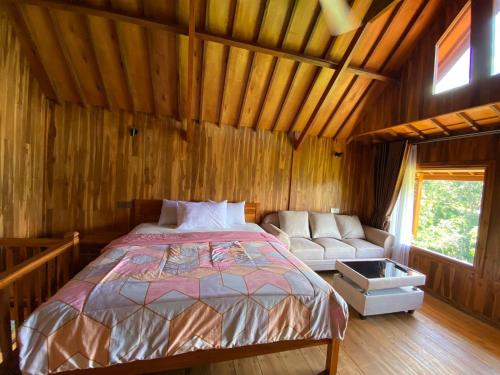 a bedroom with a bed and a couch in a room at The Alam Bungalow & Restaurant in Tetebatu
