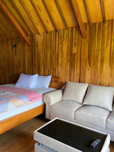 a room with a bed and a couch in a room at The Alam Bungalow & Restaurant in Tetebatu