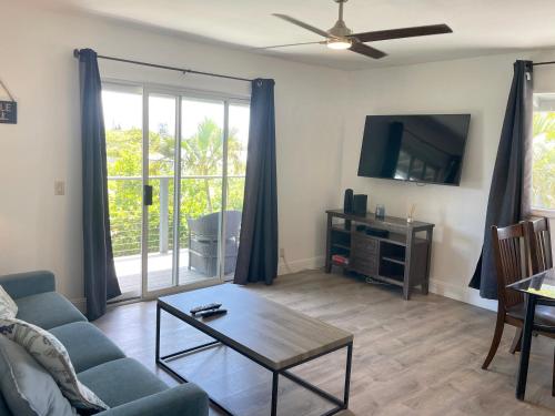 a living room with a couch and a tv at Puu Koa Palms vacation rental in Haiku