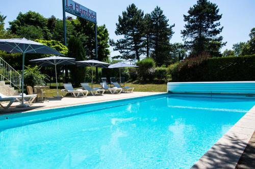 a swimming pool with chairs and umbrellas at La Flambée in Sennecey-lès-Dijon