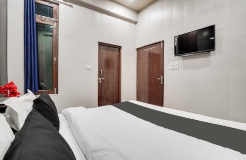 a bedroom with a bed and a flat screen tv at EMERGE HOTEl in Hardoī