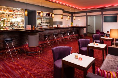 a bar in a restaurant with purple chairs and tables at Best Western Premier Parkhotel Bad Mergentheim in Bad Mergentheim