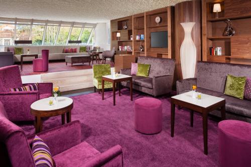 a living room with purple chairs and tables at Best Western Premier Parkhotel Bad Mergentheim in Bad Mergentheim