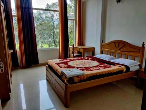 a bedroom with a bed and a large window at Winter Green Resorts, Munnar in Munnar