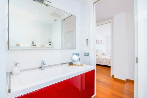 a bathroom with a red cabinet and a mirror at Llevant in Portocolom