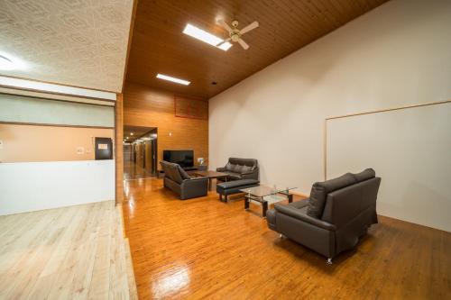 a waiting room with leather chairs and a whiteboard at Takachiho Sanso Amaterasu Kagura in Takachiho