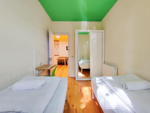 two beds in a room with a green ceiling at Guest House Bolnisi - Duplex apartment in Bolnisi