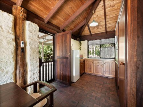 a kitchen with a table and a refrigerator in a room at Treenbrook Cottages in Pemberton