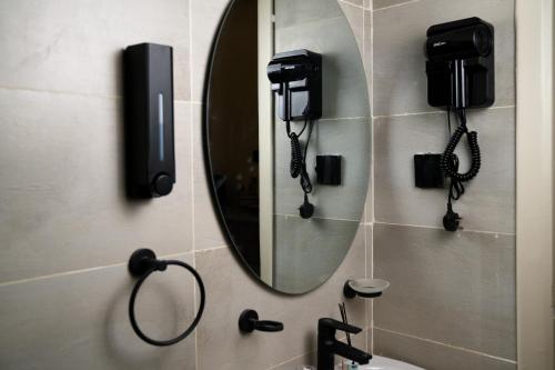 a bathroom with a mirror and phones on the wall at استديوا " بلكونه " in Riyadh