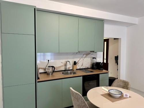 a kitchen with blue cabinets and a table at Stunning Sea View - Brand New Apartments in Kotor
