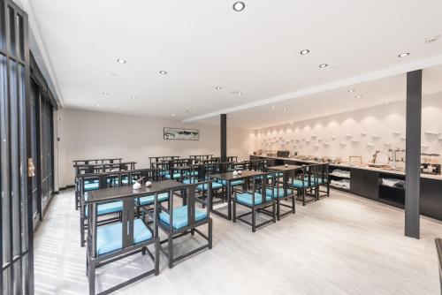 昆明Gongxili-Xijian Hotel - Kunming Dongfeng East Road Dashuying Metro Station的一间有桌子和蓝色椅子的餐厅