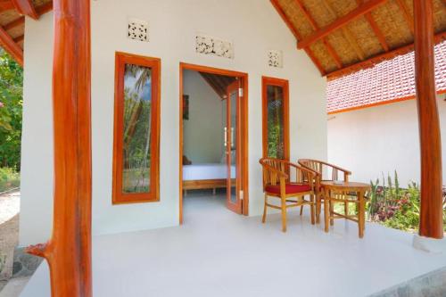 a porch of a house with a table and chairs at Dangin Kubu Pedoman in Toyapakeh