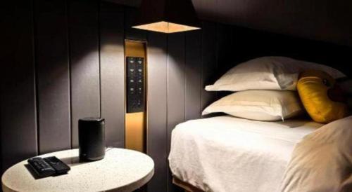 a bedroom with a bed and a table with a remote control at Movie Star Hotel in Guangzhou