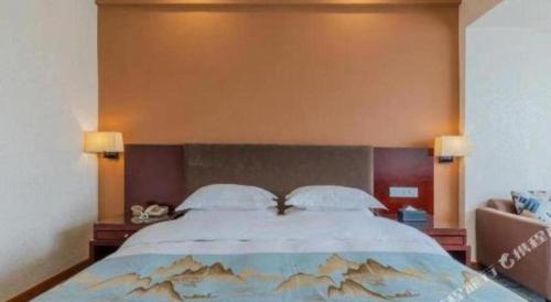 a bedroom with a large bed with two pillows at Movie Star Hotel in Guangzhou