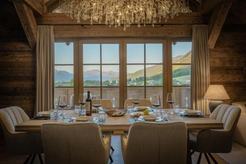 a dining room with a table with chairs and a chandelier at Arnestgut in Strobl