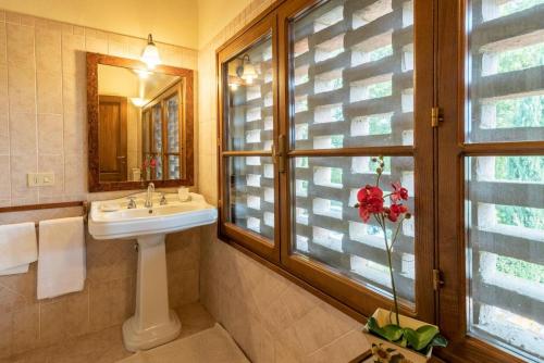 Un baño con lavabo y ventana. en Villa In The Farmhouse With Pool In Tuscany, en Bucine