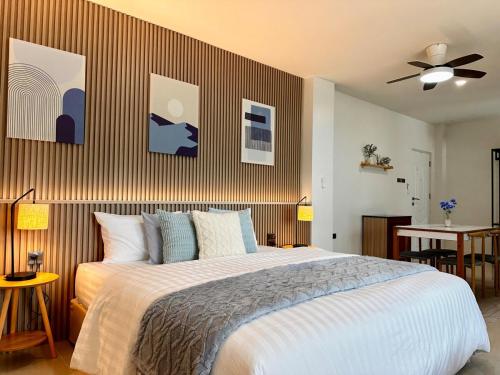 a bedroom with a large bed and a ceiling fan at Indigo Studio 2 mins from SRT Wat Samien Nari in Bangkok