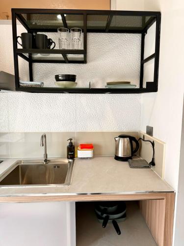 a kitchen counter with a sink and a mirror at Indigo Studio 2 mins from SRT Wat Samien Nari in Bangkok