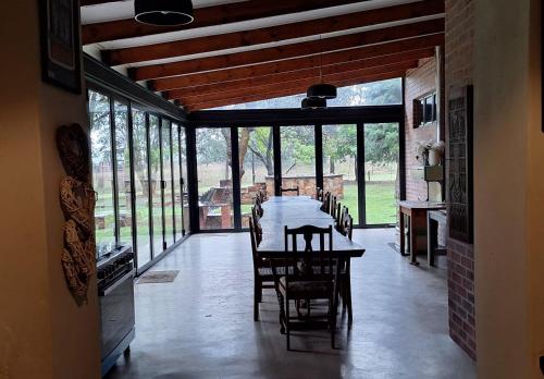una sala da pranzo con tavolo, sedie e finestre di Carlsruhe Private Game Reserve Cullinan a Vosburg