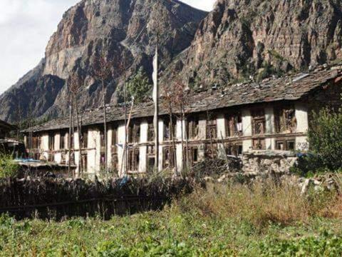 Un edificio antiguo frente a una montaña en Kailash Mansarovar Homestay, en Garbyāng