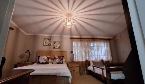 una camera con letto e lampadario a braccio di Carlsruhe Private Game Reserve Cullinan a Vosburg