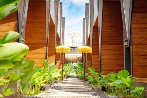 a garden with yellow umbrellas on a walkway between buildings at D'svarga Glamping in Seturan