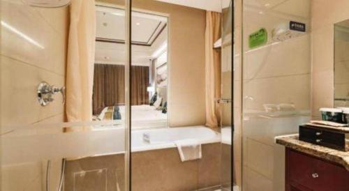a bathroom with a shower and a sink and a tub at Junyu Grand Hotel Qinhuangdao in Qinhuangdao