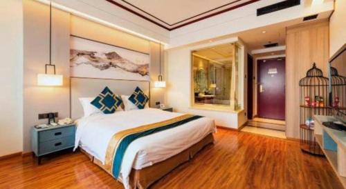 a bedroom with a large bed and a bathroom at Junyu Grand Hotel Qinhuangdao in Qinhuangdao