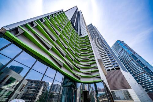 a tall building with glass windows in a city at Kingkey Shuibei International Apartment Hotel in Shenzhen