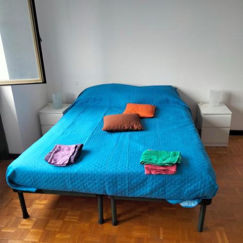 a blue bed with colorful pillows and towels on it at Carlo e Dani Flat in Venice in Venice