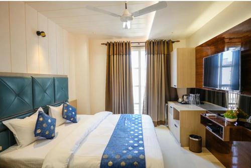 a hotel room with a bed and a flat screen tv at Hamirgarh Herriitage palace kumbhalgarh in Kumbhalgarh