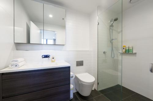 Un baño con lavabo, inodoro y ducha. en Luxury Living and Pool Views in the Heart of Woden - Hosted by Canstay, en Phillip