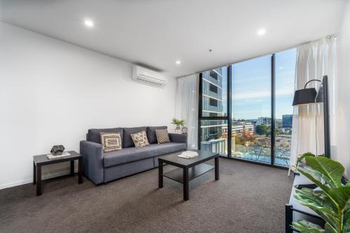a living room with a couch and a large window at Luxury Living and Pool Views in the Heart of Woden - Hosted by Canstay in Phillip