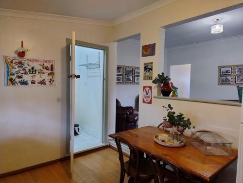 a dining room with a table and chairs and a door at Corella Accommodation - 1F in Boulder