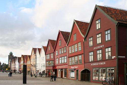 une rangée de bâtiments rouges et blancs dans une rue dans l'établissement CozyStay Beside Historic Bryggen, à Bergen
