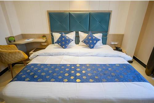 a large bed with a blue headboard in a room at Hamirgarh Herriitage palace kumbhalgarh in Kumbhalgarh