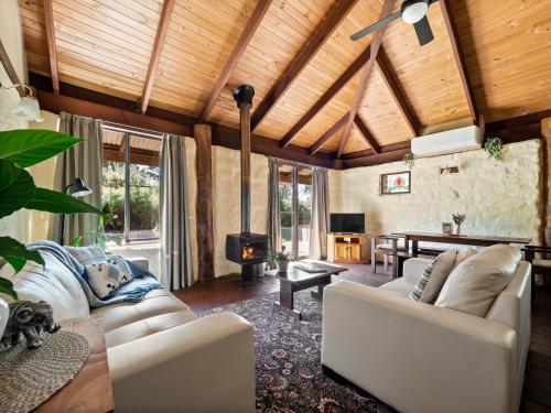a living room with couches and a wood ceiling at Treenbrook Cottages in Pemberton